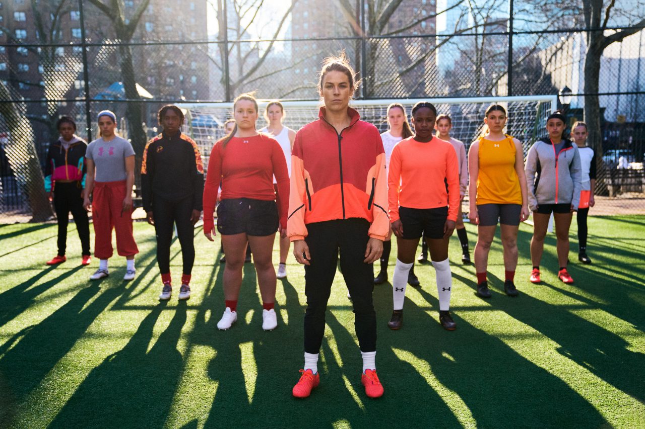 Kelley O'Hara standing alongside female soccer players