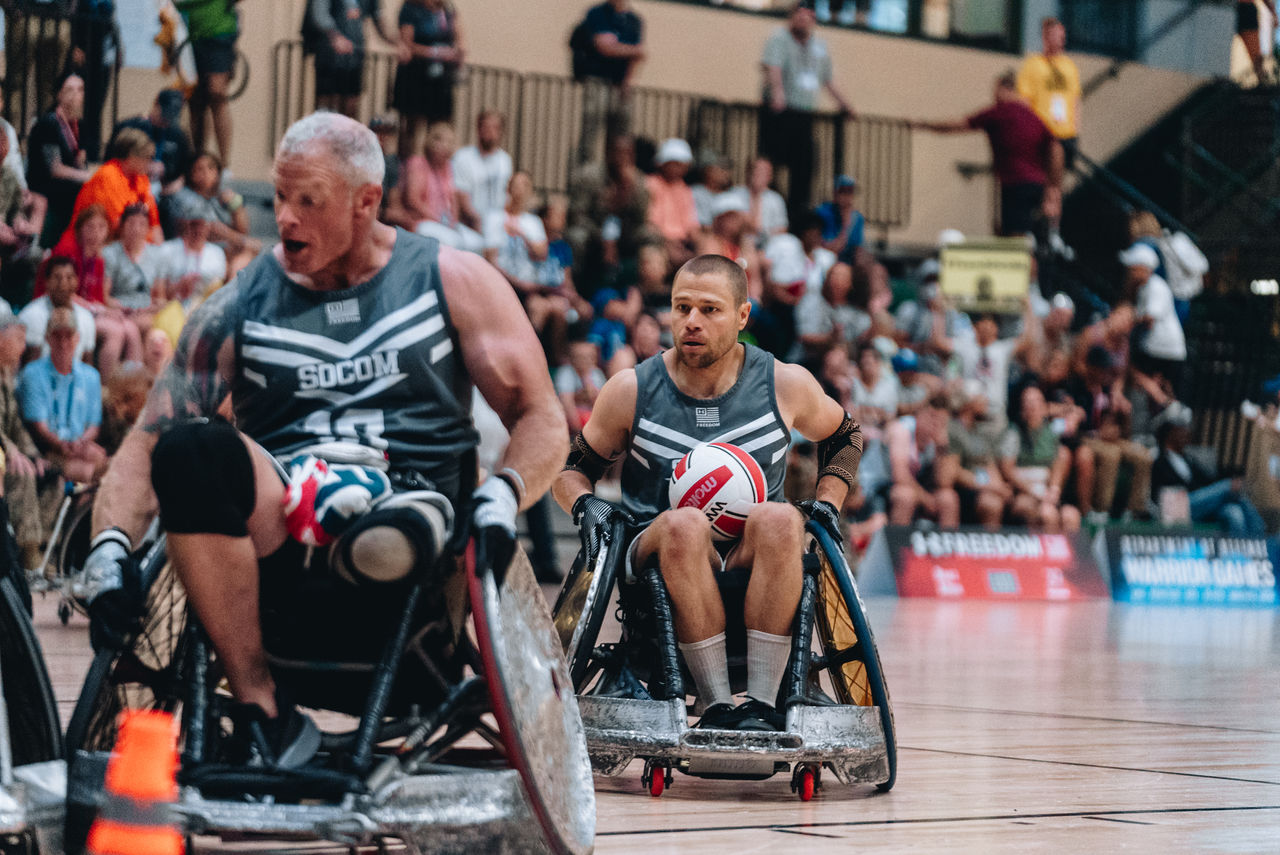 two men in wheelchairs on a basketball court