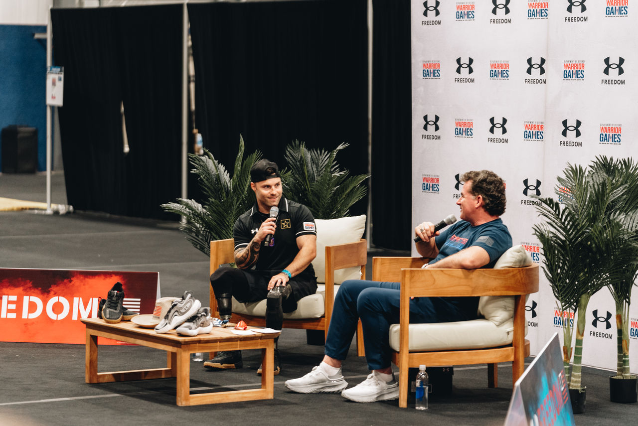 two men seated in chairs talking