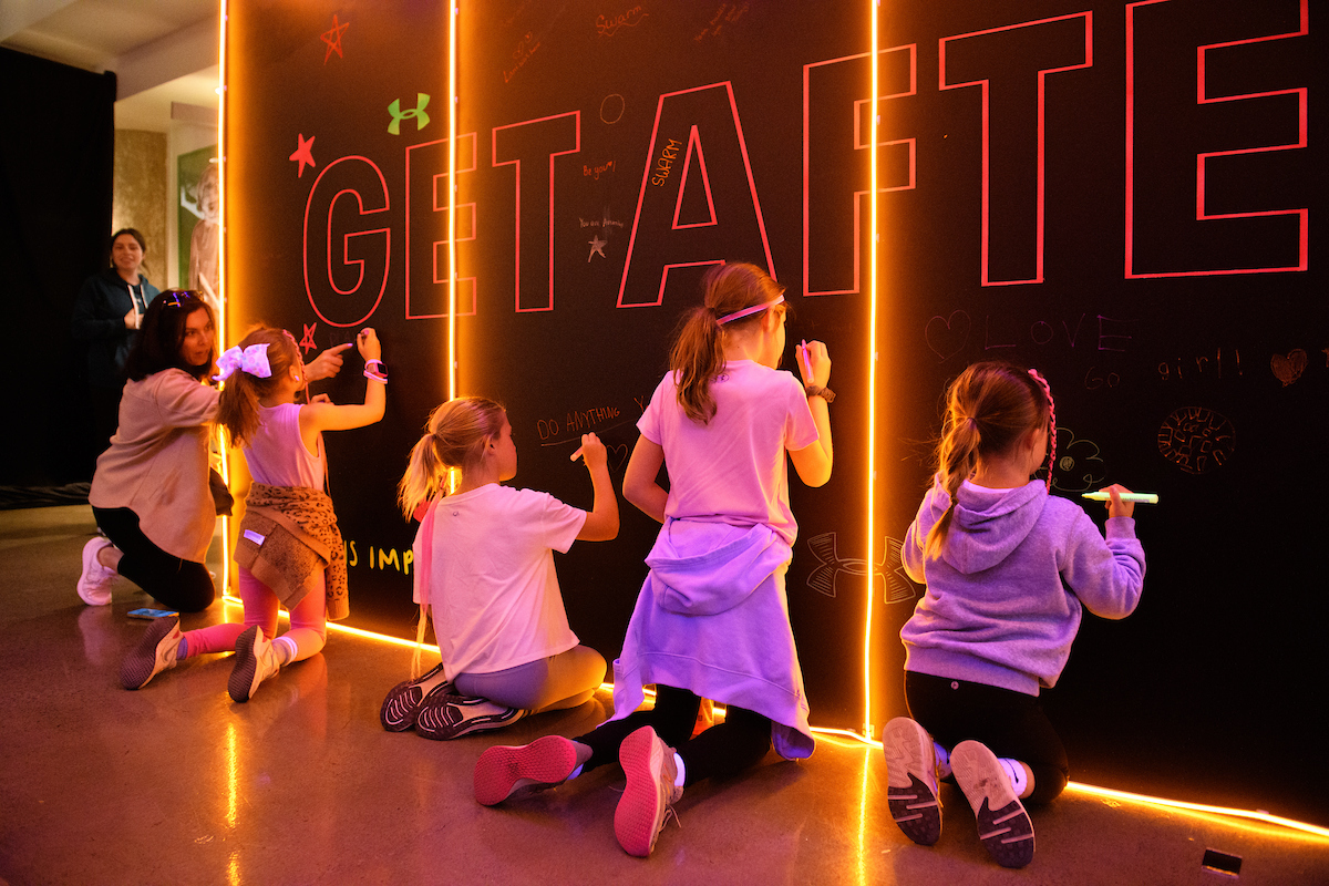 De jeunes athlètes féminines écrivent sur le mur des Headqaurters de Hype